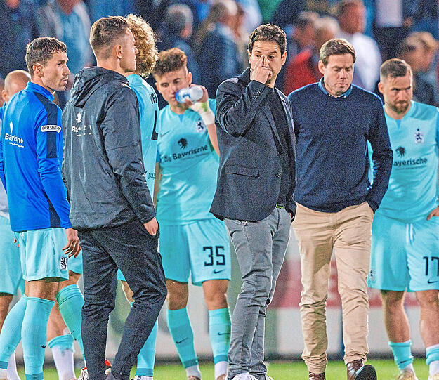 Bediente Giesinger: Die Löwen um Trainer Giannikis (3.v.r.) und Sportchef Werner (2.v.r.) stehen nach der Pleite in Haching bedröppelt auf dem Rasen. Foto: Oryk Haist/imago
