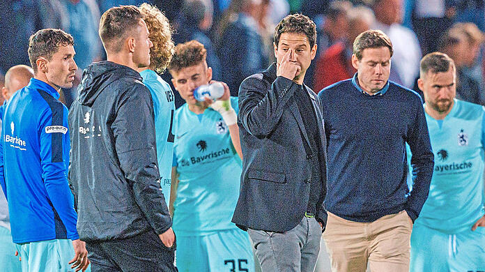 Bediente Giesinger: Die Löwen um Trainer Giannikis (3.v.r.) und Sportchef Werner (2.v.r.) stehen nach der Pleite in Haching bedröppelt auf dem Rasen. Foto: Oryk Haist/imago