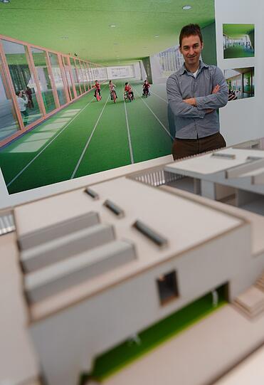 Johannes Talhof vom Architekturbüro Hess Talhof Kusmierz steht am im Deutschen Architekturmuseum (DAM) in Frankfurt am Main hinter einem Modell der Grundschule am Arnulfpark in München.