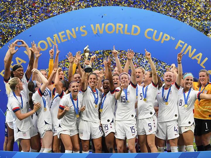 Carli Lloyd (M) hält den WM-Pokal inmitten der jubelnden US-Spielerinnen.