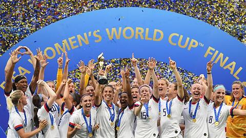 Carli Lloyd (M) hält den WM-Pokal inmitten der jubelnden US-Spielerinnen.