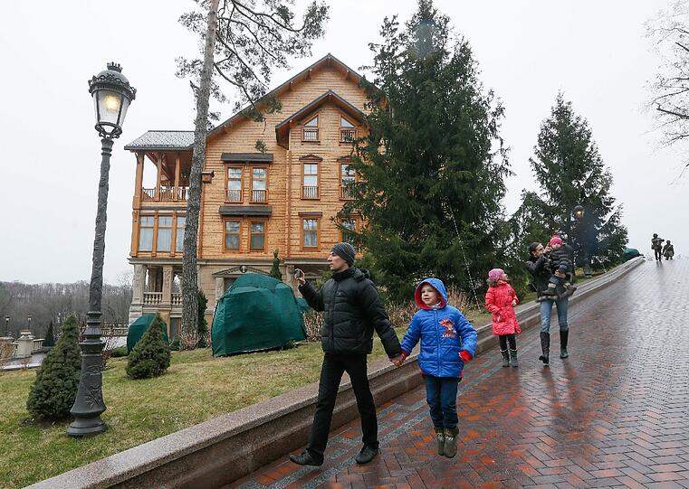 Eine Familie auf dem Weg zur Prunk-Villa von Viktor Janukowitsch. Demonstranten haben seine Residenz vor den Toren Kiews eingenommen und für die Öffentlichkeit zugänglich gemacht. Die Bilder.