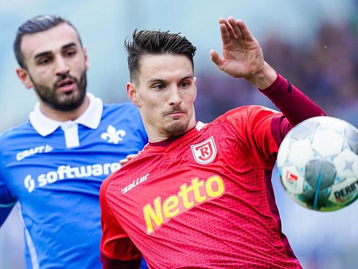 Darmstadts Serdar Dursun (l) und Regensburgs Sebastian Stolze kämpfen um den Ball.