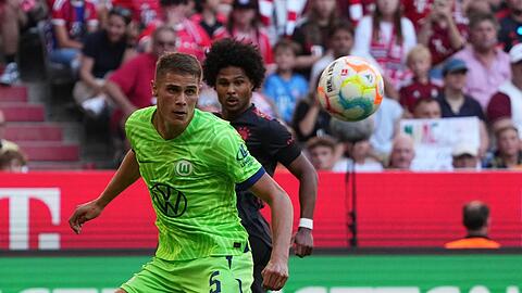 Wolfsburgs Micky van de Ven und Münchens Serge Gnabry kämpfen um den Ball.