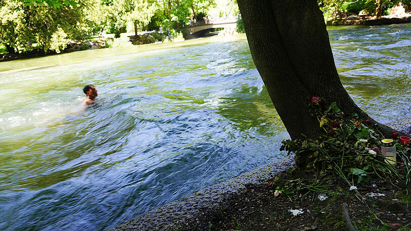 Blumen am Baum zeigen die Stelle, an der vor rund zwei Wochen ein 15-jähriges Mädchen im Eisbach ertrunken ist.