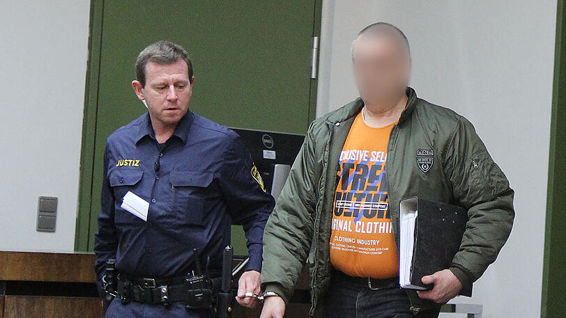 Der Angeklagte (r.) wird in den Gerichtssaal gebracht.