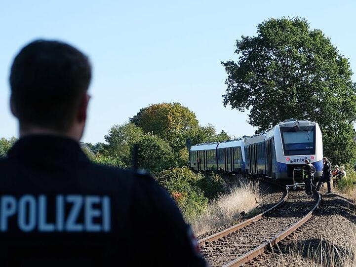 Ein Polizist steht in der Nähe des Unglücksortes auf dem Bahngleis bei Isenbüttel.