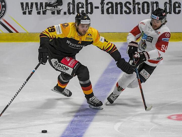 Leon Draisaitl von Deutschland und Marco Richter von Österreich (l-r.) im Zweikampf um den Puck. Foto: Armin Weigel
