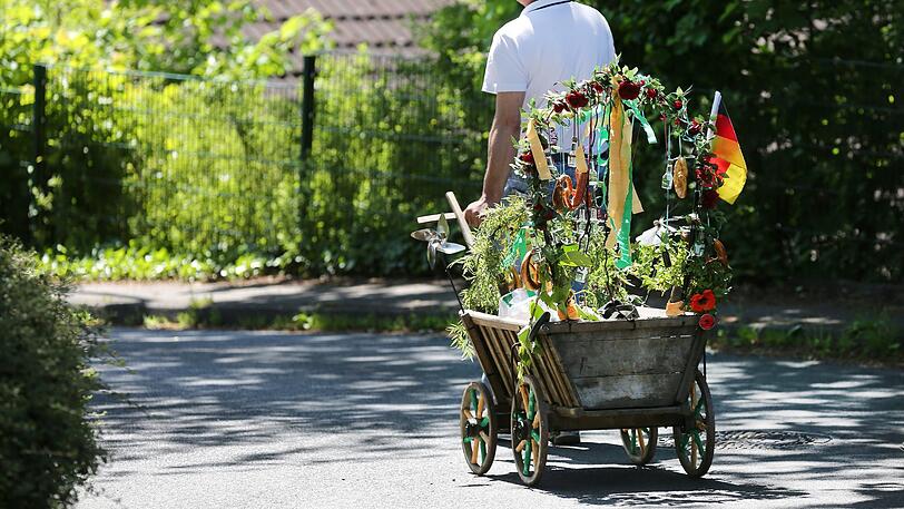 Ein Mann zieht zum Vatertag in einen Bollerwagen über einen Waldweg.