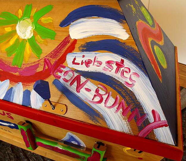 "Liebstes Neon-Bunny", steht in geschwungenen roten Buchstaben auf dem bunten Sarg.