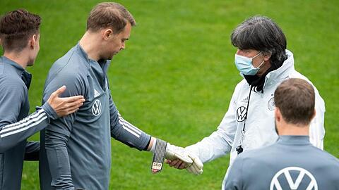 Manuel Neuer zeigt Bundestrainer Joachim Löw die Torwarthandschuhe für sein 100. Länderspiel.