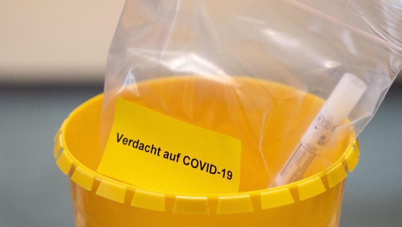 Ein Teströhrchen liegt in einer Tüte mit der Aufschrift "Verdacht auf COVID-19". (Symbolbild). Ein Teströhrchen liegt in einer Tüte mit der Aufschrift "Verdacht auf COVID-19". (Symbolbild).