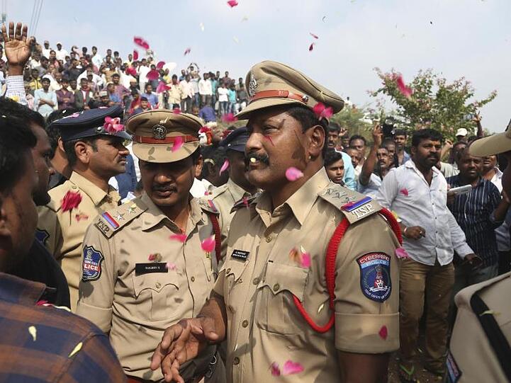 Indische Polizisten bewachen ein Gebiet etwa 50 Kilometer von Hyderabad, in dem vier mutmaßliche Vergewaltiger von der Polizei erschossen wurden.