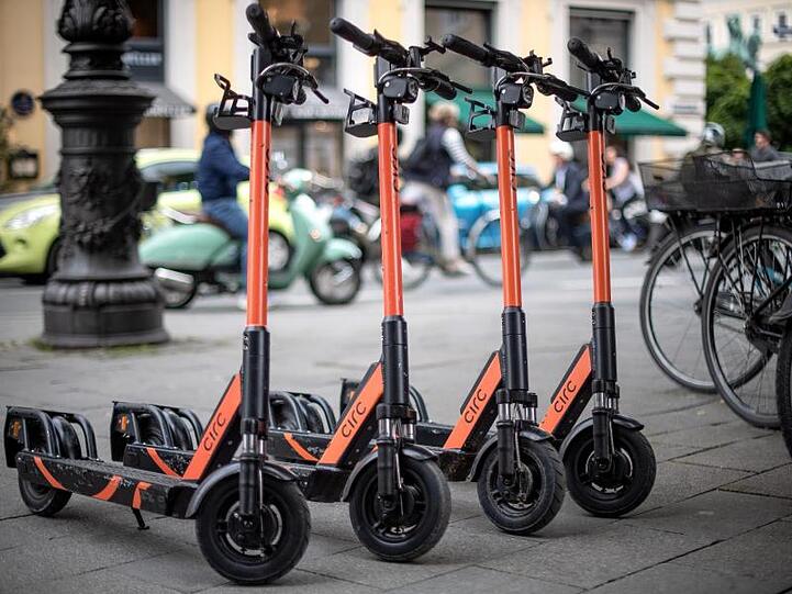 E-Tretroller stehen auf einem Fußweg in München. Foto: Sina Schuldt/dpa/Archivbilder
