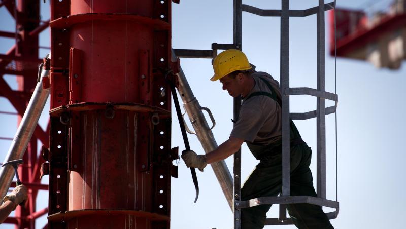 Ein Arbeiter montiert an einem Kran. Foto: Alexander Heinl/Archivbild