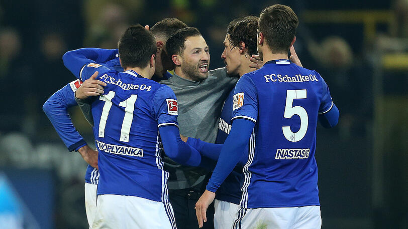 Schalke-Trainer Domenico Tedesco (Mitte) wird nach dem 4:4 gegen Dortmund von seinen Spielern bejubelt.