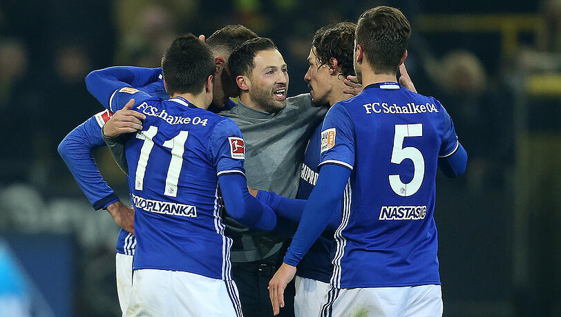 Schalke-Trainer Domenico Tedesco (Mitte) wird nach dem 4:4 gegen Dortmund von seinen Spielern bejubelt. Schalke-Trainer Domenico Tedesco (Mitte) wird nach dem 4:4 gegen Dortmund von seinen Spielern bejubelt.