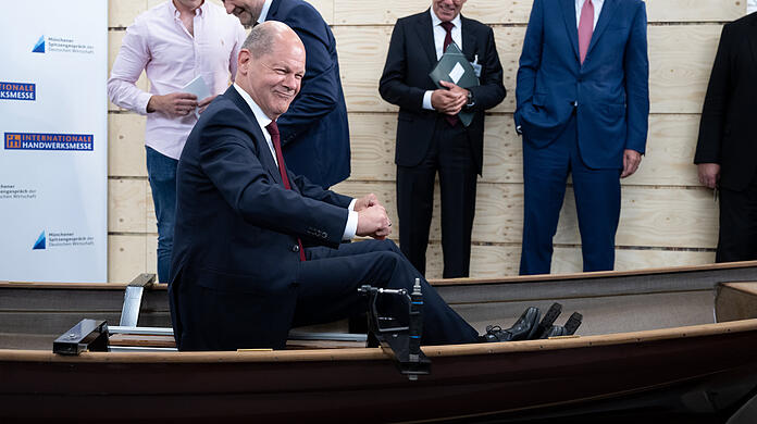 Bundeskanzler Olaf Scholz (SPD) sitzt bei einem Rundgang über die Internationale Handwerksmesse (IHM) am Messestand der Firma Baumgarten Bootsbau in einem Boot. Scholz und Vertreter der Wirtschaft trafen sich im Rahmen der Internationalen Handwerksmesse IHM.