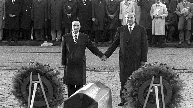 Hand in Hand: Stellvertretend für ihre lange verfeindeten Völker reichen sich der französische Staatspräsident François Mitterrand (l.) und
Bundeskanzler Helmut Kohl über den Gräbern von Verdun die Hände.