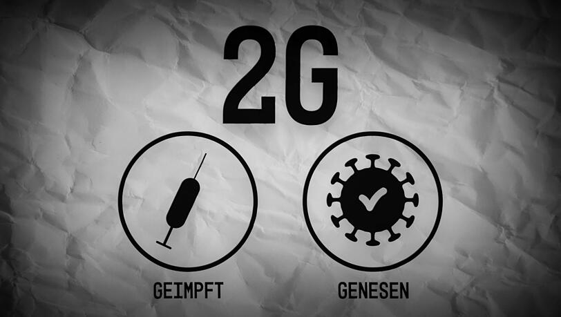 Ein zerknitterter Zettel in einem Geschäft, der die 2G-Regel erklärt. Ein zerknitterter Zettel in einem Geschäft, der die 2G-Regel erklärt.