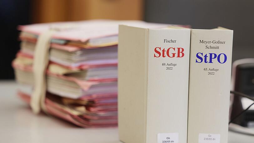Gerichtsakten und Bücher zu Strafgesetzbuch und Strafprozessordnung.