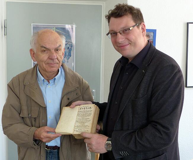 Die Übergabe: Rainer Vogel (l.) händigt im Namen der Schenkerin das Buch dem Staatsbibliotheksleiter Bernhard Luebbers aus.