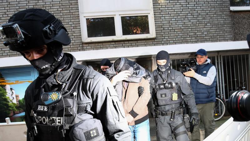 Terror-Razzia in Hamburg: Ein Mann wird von Polizisten aus einem Haus geführt. Terror-Razzia in Hamburg: Ein Mann wird von Polizisten aus einem Haus geführt.