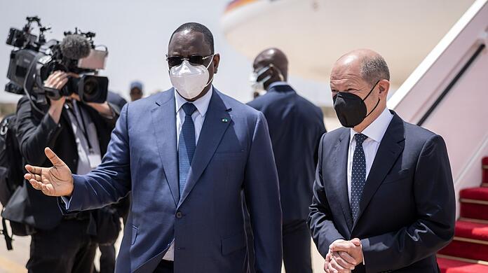 Bundeskanzler Olaf Scholz (r, SPD), wird von Macky Sall, Präsident der Republik Senegal mit militärischen Ehren am Flughafen begrüßt.