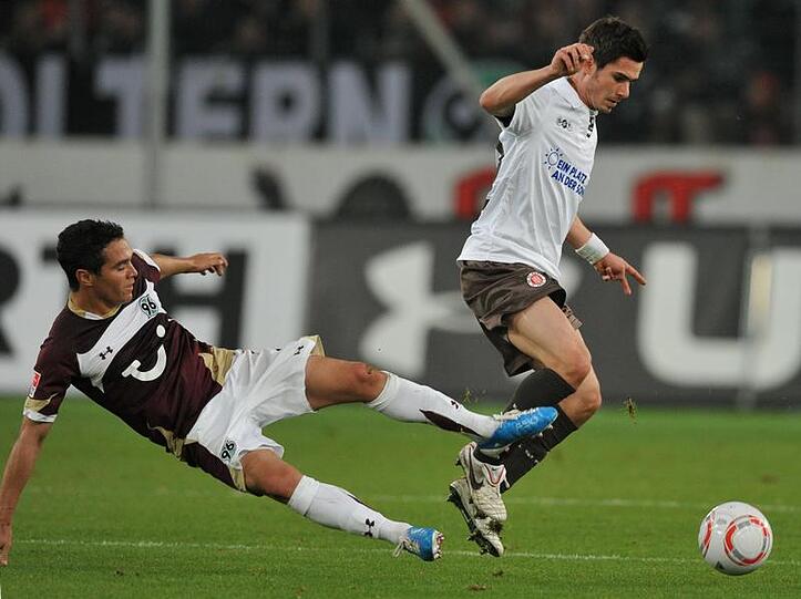 Hannovers Manuel Schmiedebach (l) versucht mit einem Sprung St. Paulis Fin Bartels vom Ball zu trennen.