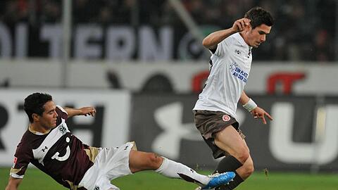 Hannovers Manuel Schmiedebach (l) versucht mit einem Sprung St. Paulis Fin Bartels vom Ball zu trennen.