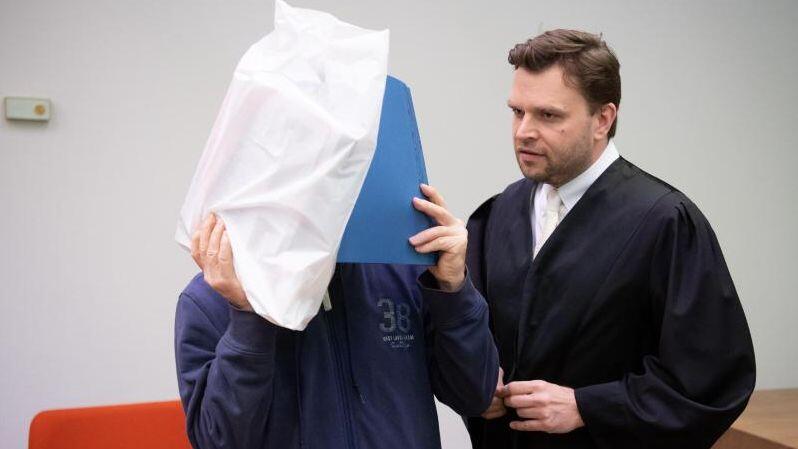 Der Angeklagte (l.) und sein Verteidiger stehen im Gericht.