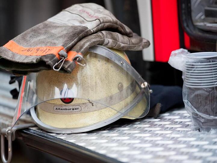 Ein Feuerwehrhelm liegt an einem Einsatzfahrzeug. Foto: picture alliance/dpa/Symbolbild