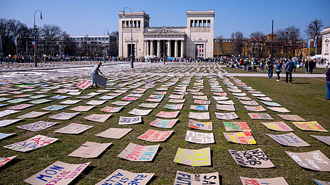 Zahlreiche Menschen nehmen an einer Demonstration zum globalen Klimastreik teil und haben Plakate mit ihren Forderungen auf den Königsplatz gelegt.
