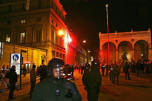 Am Odeonsplatz schießen Demonstranten Leuchtkugeln auf die Residenz.