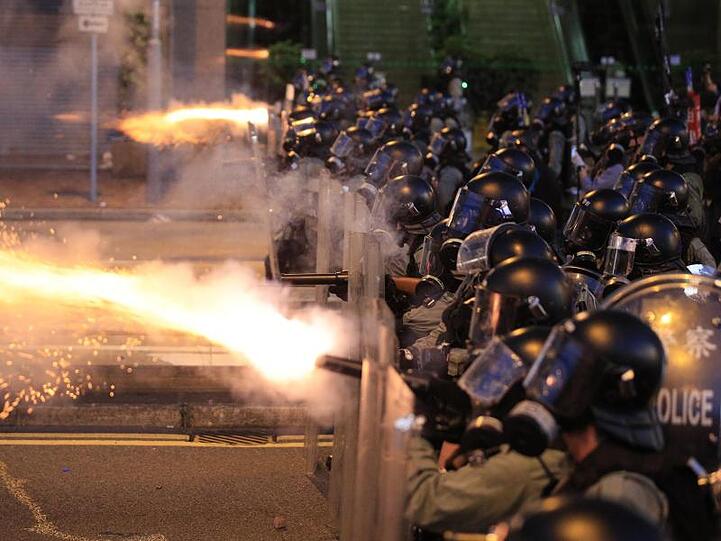 Die Polizei von Hongkong feuert Tränengas auf Demonstranten.