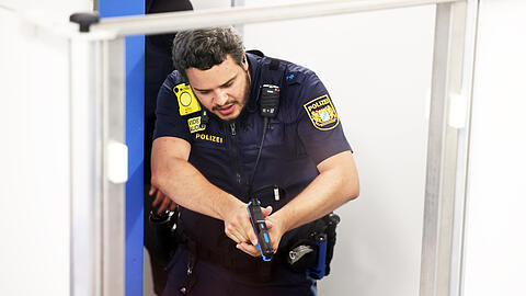 Ein Polizeibeamter w&auml;hrend eines Einsatztrainings im Keller des Polizeipr&auml;sidiums. Am Ende muss er seine Waffe ziehen.