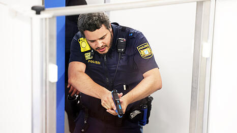 Ein Polizeibeamter w&auml;hrend eines Einsatztrainings im Keller des Polizeipr&auml;sidiums. Am Ende muss er seine Waffe ziehen.