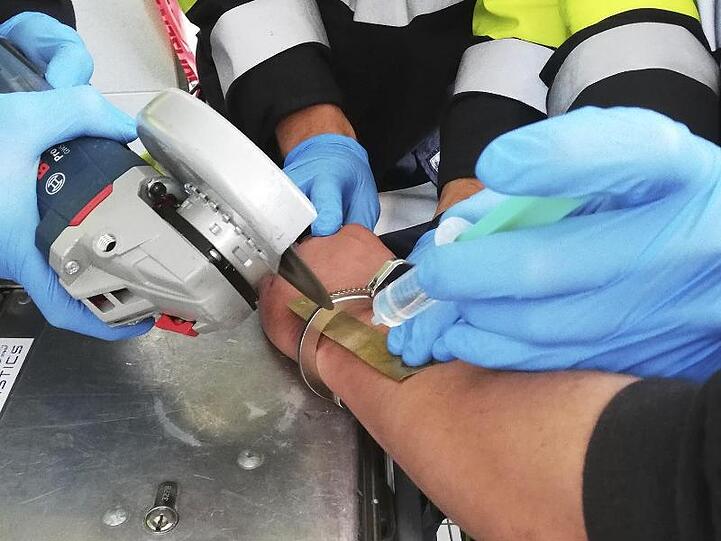 Einsatzkräfte der Feuerwehr flexen die Handschelle vom Arm eines 36-Jährigen Mannes. Foto: Feuerwehr München