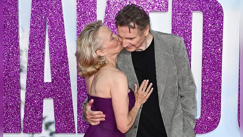 Pamela Anderson knutscht Liam Neeson auf die Wange - der scheint es sichtlich zu genießen.