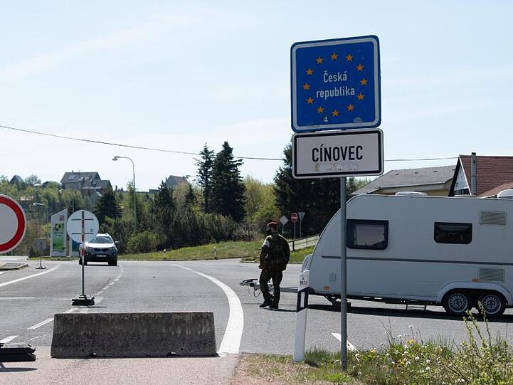 Ein tschechischer Soldat mit Mundschutz geht an der tschechischen Grenze an einem Wohnwagen entlang. Foto: Sebastian Kahnert/dpa-Zentralbild/dpa/Archivbild