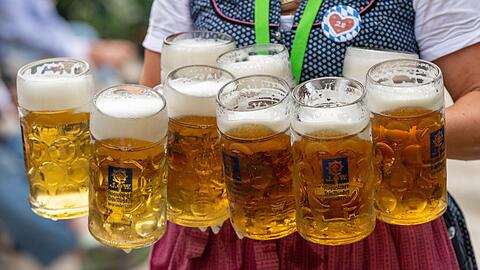 Eine Bedienung trägt acht Maß Bier.