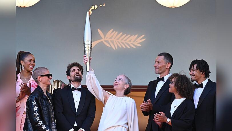 Delphine Ernotte, Präsidentin der Europäischen Rundfunkunion, reckt in Cannes die Olympische Fackel in die Höhe. Delphine Ernotte, Präsidentin der Europäischen Rundfunkunion, reckt in Cannes die Olympische Fackel in die Höhe.