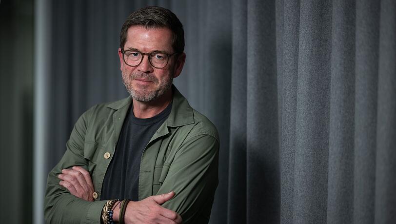 Karl-Theodor zu Guttenberg steht vor einem Vorhang.
