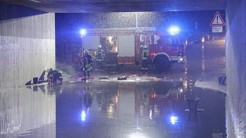 Feuerwehrleute sind in M&uuml;nchen im Einsatz. Teils heftige Gewitter mit Starkregen, Hagel und Sturmb&ouml;en sind &uuml;ber Teile Bayerns hinweggezogen.