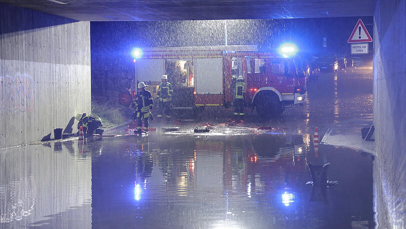 Feuerwehrleute sind in M&uuml;nchen im Einsatz. Teils heftige Gewitter mit Starkregen, Hagel und Sturmb&ouml;en sind &uuml;ber Teile Bayerns hinweggezogen.