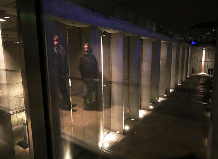 Der Eingang zum Agyptischen Museum liegt viereinhalb Meter unterhalb des Geländeniveaus. In einer gewaltigen Portalwand befindet sich eine schmale Öffnung als Eingang zum unterirdischen Museum. Er erweckt Assoziationen an eine Grabkammer. Die Skulpturensäle haben fugenlose Sichtbeton-Wände bis zu einer Höhe von 6.40 Meter mit ganz glatten Oberflächen. Je weiter man in das Museum vordringt, desto kleiner werden die Räume für die Exponate. Tageslicht bekommen die Räume von einem Lichthof. Mit den Materialien Beton Glas und Stahl konzipierte Architekt Peter Böhm den 35-Millionen-Bau.