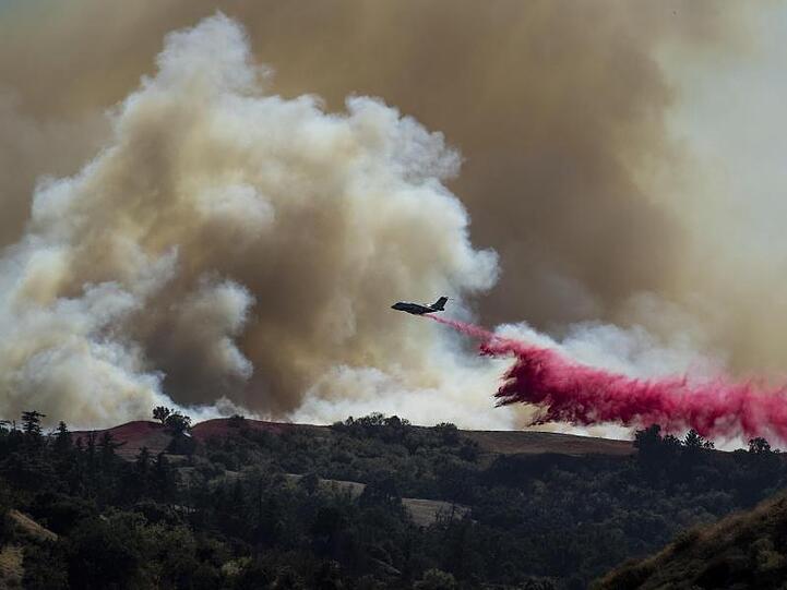 Die Feuerwehr setzt für Löscharbeiten der Waldbrände ein Löschflugzeug ein.