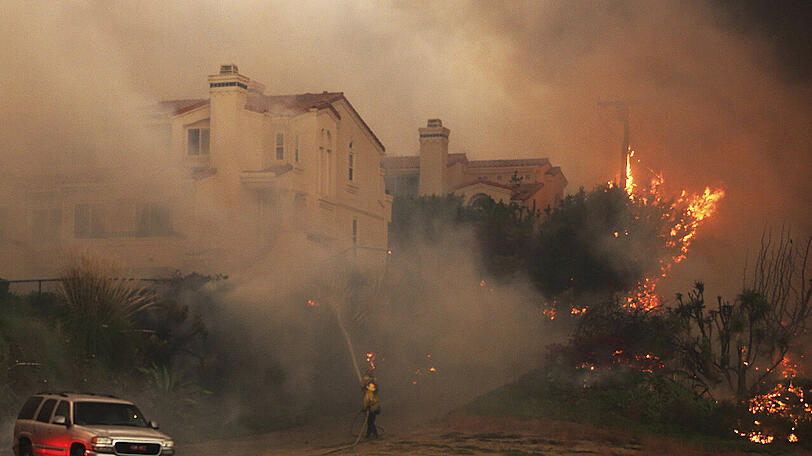 Feuerwehrleute kämpfen gegen die Flammen in dem Wohnkomplex am Pacific Coast Highway im Point Dume Gebiet.