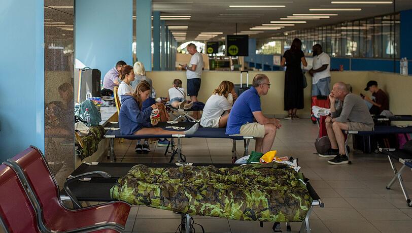 Von den Waldbränden betroffene Touristen warten am internationalen Flughafen Diagoras auf ihren Flug. Von den Waldbränden betroffene Touristen warten am internationalen Flughafen Diagoras auf ihren Flug.