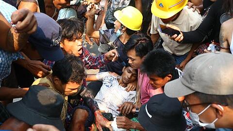 Demonstranten umringen einen Verletzten bei einem Protest gegen den Militärputsch in Yangon.